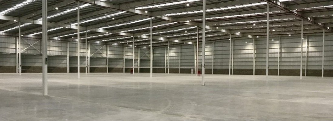 Interior de nave logística con piso industrial y estructura metálica